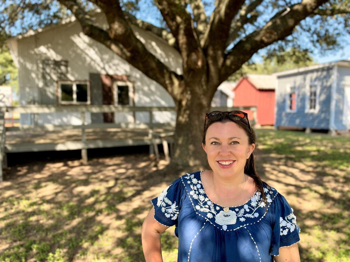Brandy under a big live oak in Sealy, with the old buildings behind her.